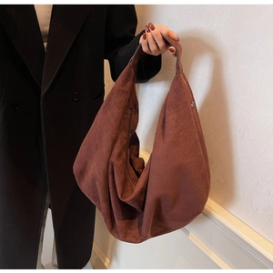 Close-up of a large coffee brown suede Hobo bag with a matte texture and wide shoulder strap