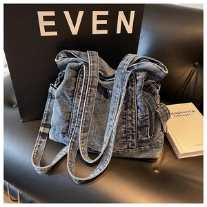 Detail of vintage washed denim tote bag with side metal zipper and thick texture