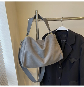 Detail view of the soft grey suede material and durable golden hardware on this shoulder bag