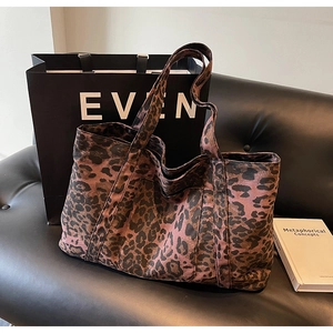 Detailed close-up showing the leopard print texture and sturdy handles of this large tote bag