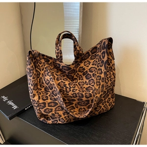 Detailed view of leopard print tote bag with wide shoulder strap and dual handles