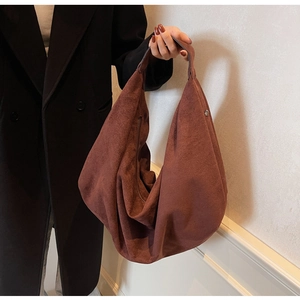 Detail of deep brown suede hobo bag featuring premium texture and side metal zipper