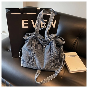 Street style denim tote bag with front snap pocket and side zipper on a black bench