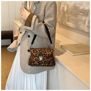 Close-up of leopard print shoulder bag with silver buckle and horsehair texture detail