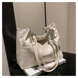 Detail of off-white tote bag with silver chain strap and soft leather texture