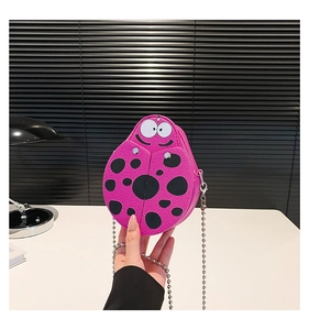 Close-up of pink ladybug shaped mini crossbody bag with black polka dots and silver ball chain