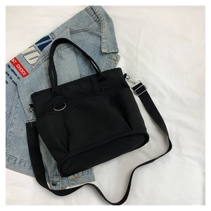 Detail of black canvas tote bag with multi-pockets and adjustable shoulder strap