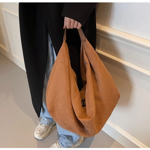 Macro view of caramel brown suede tote bag showing soft texture and wide shoulder strap