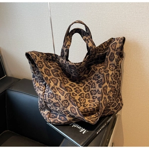 Large leopard print canvas tote bag detail showing texture on a leather sofa