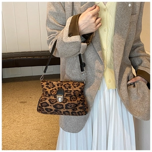 Detailed view of a leopard print shoulder bag featuring a silver metal push-lock closure