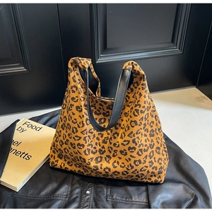 Gros plan d'un sac cabas imprimé léopard avec des bandoulières en cuir noir premium