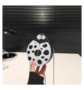 Detail of ladybug cartoon mini chain bag with black and white polka dots and metal zipper