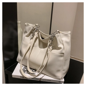 Detail of soft cream tote bag showing silver chain straps and fine pebbled texture