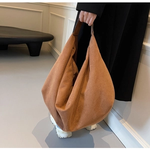 Detail shot of a large brown suede hobo bag with a minimalist shoulder strap design