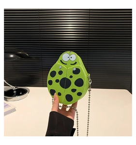 Detail of green ladybug-shaped mini crossbody bag with large cartoon eyes and silver chain