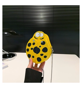 Detail of yellow ladybug mini crossbody bag featuring textured PU leather and smile pattern