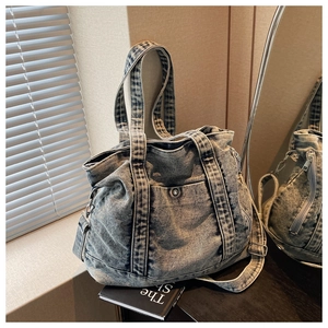 Detailed macro view of retro washed denim tote with adjustable strap and metal snap pocket