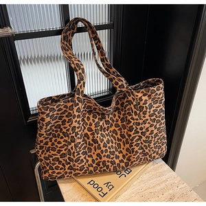 Detail of large capacity leopard print tote bag placed on vintage books