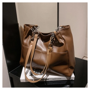 Detail of soft brown PU leather tote with silver metal chain strap and side pocket