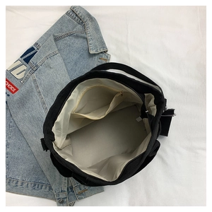 Internal view of black canvas tote bag featuring a spacious inner lining and zipper pocket