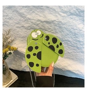 Detail of green ladybug crossbody bag with lychee texture and silver chain strap