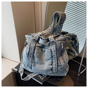 Close-up of vintage blue washed denim tote bag with metal snap pocket and sturdy stitching