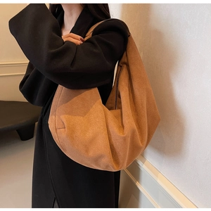 Brown matte suede tote bag shown on model wearing a black coat for daily commute styling