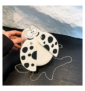 Detailed view of mini white crossbody bag with cute ladybug dots and metal chain strap