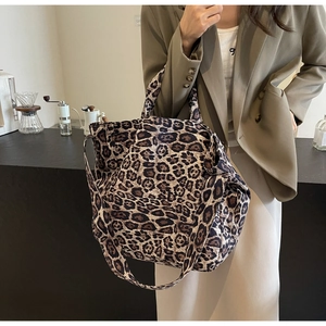 Detail view of large leopard print tote bag with double handles and wide shoulder strap