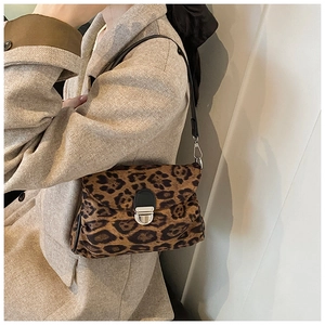 Detailed view of vintage leopard print crossbody bag with silver buckle on beige coat