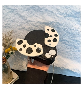Detail shot of mini cartoon dog shoulder bag with litchi texture and metal chain