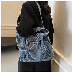 Detail view of large denim tote bag showing vintage washed texture and shoulder carry style