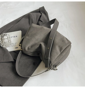 Detailed macro view of retro grey suede baguette bag texture with gold metal hardware