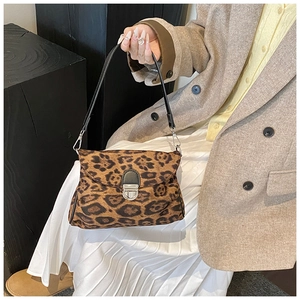 Detail of leopard print underarm bag with silver metal buckle and black slim strap