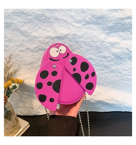Detail of pink ladybug shaped mini bag showing lychee grain faux leather and metal chain
