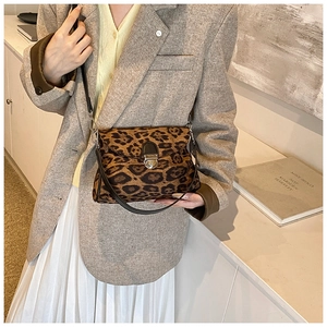 Detailed close-up of leopard print crossbody bag with gold metal lock and dual straps