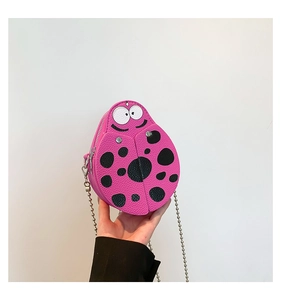 Detailed close-up of a pink ladybug mini crossbody bag with a silver chain strap