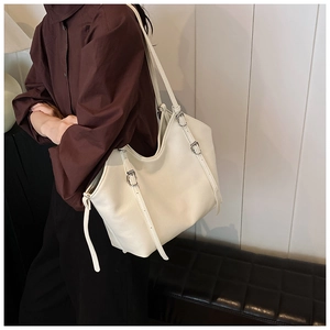 Macro detail of cream tote bag featuring vertical strap accents and premium faux leather