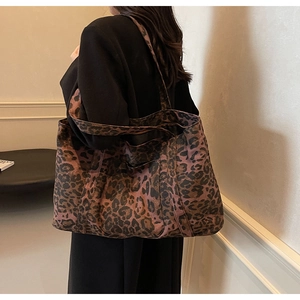 Close-up of a large leopard print tote bag showing the canvas texture and shoulder strap