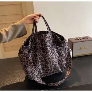 Detailed close-up of leopard print canvas tote bag with thick shoulder strap and handles