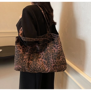 Detailed side view of the large leopard print tote bag being worn by a fashion model