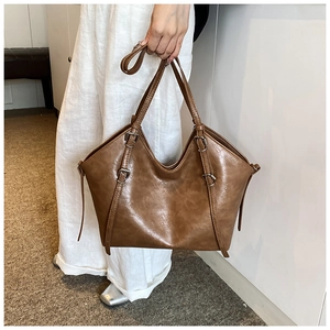 Detailed macro view of retro brown tote bag showing high-quality PU leather texture and buckles