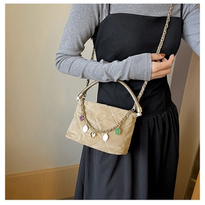 Quilted beige velvet crossbody bag with elegant gold handles and colorful heart charms