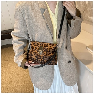 Detail shot of leopard print crossbody bag with vintage silver metal clasp and leather strap