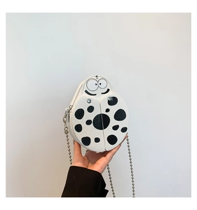 Detail of cartoon ladybug crossbody bag in white PU leather with silver chain strap