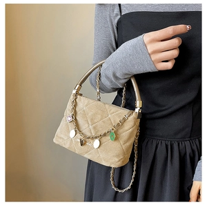 Detailed close-up of khaki quilted velvet handbag with elegant golden heart charms