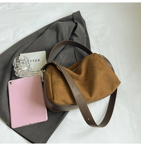Detail view of suede hobo bag with vintage metal rivets and premium leather accents