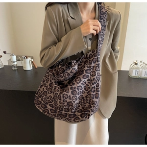 Close-up of leopard print canvas shoulder bag with hobo style design and wide strap