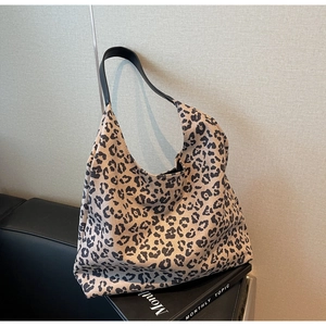 Gros plan du sac hobo à imprimé léopard avec bandoulière en cuir noir et textures