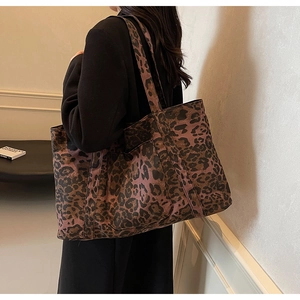 Close-up of leopard print tote bag showing wide shoulder strap and fabric texture